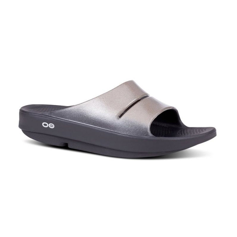 Angled side view of OOfos Women's OOahh Luxe Slide sandal in black/latte.
