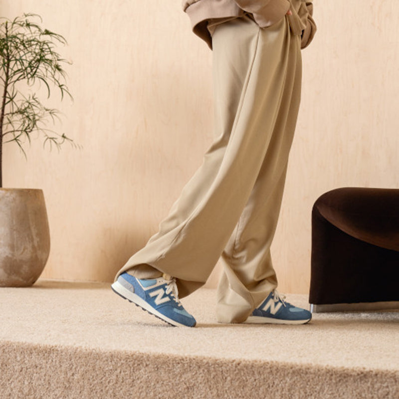 Woman wearing New Balance Women's 574 Sneaker in Alpine Blue/ White.